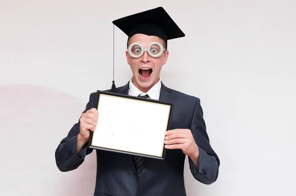卒業証明書は 灰色の背景に分離の手でキャップの持株の大学院します 教育コンセプト — ストック写真