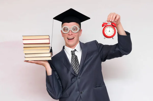 Glücklicher Doktorand Mit Büchern Und Rotem Wecker Auf Grauem Hintergrund — Stockfoto