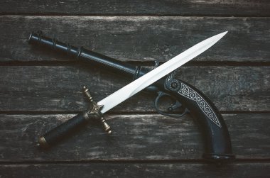 Ahşap masa arka plan üzerinde tüfek silah ve hançer bıçak. 