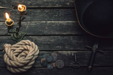 Korsan Kaptan tabloyla korsan şapkasını, halatı, silah, sikke ve yanan mum. Hazine avcısı kavramı.