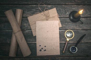 Boş mektup sayfa, Büyüteç Camı, yanan mum ve ahşap Resepsiyon arka plan üzerinde tüy kalem.