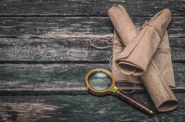 Papierrolle Und Lupe Auf Hölzernem Tischhintergrund — Stockfoto