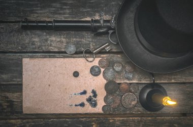 Boş sayfa gizli mektup, silah, para, melon şapka, paslı anahtar ve yanan mum ahşap Resepsiyon masasında. Retro tarzı Dedektif aracı tablo.
