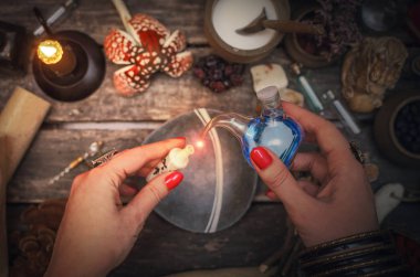 Cadı kadın paranormal tablo arka plan üzerinde sihirli bir iksir hazırlanıyor. Büyücülük kavramı.