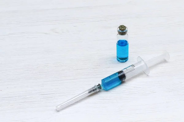 Spritze Und Ampulle Mit Blauer Flüssigkeit Auf Dem Arzttisch — Stockfoto