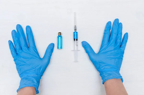 Manos Guantes Medicinales Jeringa Con Medicamento Líquido Azul Fondo Mesa — Foto de Stock