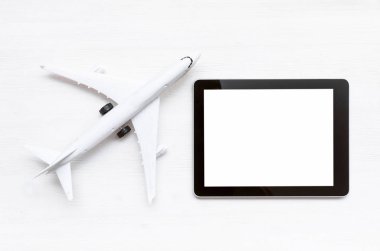 Oyuncak uçak ve beyaz ahşap masa arka plan boş ekran mobil tablet bilgisayarınızla.