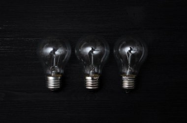 Arka plan Işık Ampüller siyah ahşap masa üzerinde yüzey.