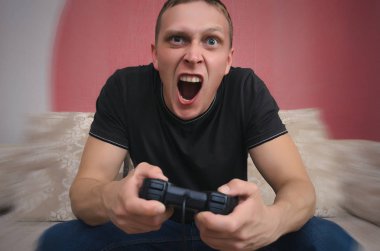 Kızgın oyun adam elinde gamepad ile video oyun oynuyor. Bir oyun kavramı kaybetmek.