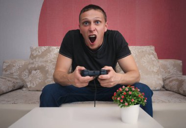 Kızgın oyun adam elinde gamepad ile video oyun oynuyor. Bir oyun kavramı kaybetmek.