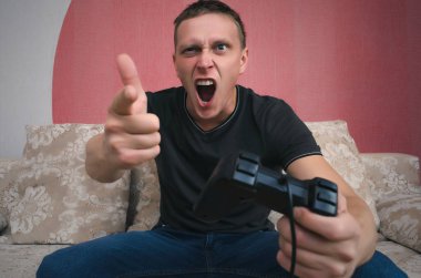 Kızgın oyun adam elinde gamepad ile video oyun oynuyor. Bir oyun kavramı kaybetmek.