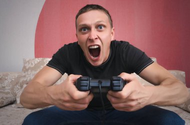 Kızgın oyun adam elinde gamepad ile video oyun oynuyor. Bir oyun kavramı kaybetmek.