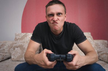 Kızgın oyun adam elinde gamepad ile video oyun oynuyor. Bir oyun kavramı kaybetmek.
