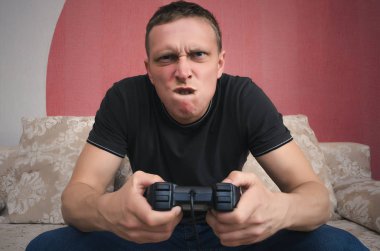 Kızgın oyun adam elinde gamepad ile video oyun oynuyor. Bir oyun kavramı kaybetmek.