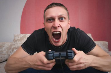 Kızgın oyun adam elinde gamepad ile video oyun oynuyor. Bir oyun kavramı kaybetmek.