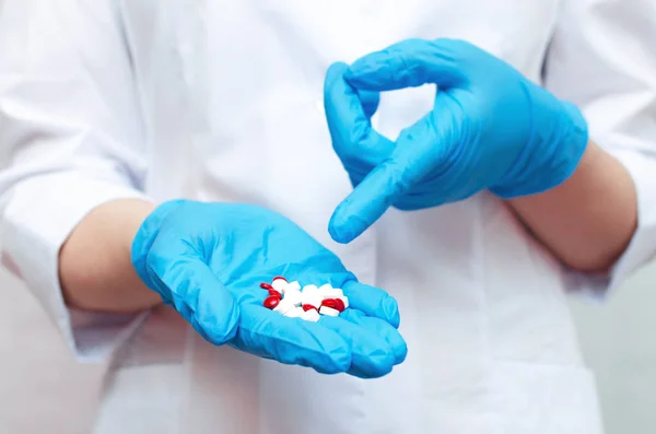 Comprimidos Vermelhos Brancos Comprimidos Mão Médico Vestido Com Luvas Médicas — Fotografia de Stock