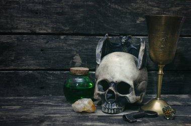 Sihirli iksir, pirinç kadehi ve sihirli tablo arka plan üzerinde insan kafatası. Büyücülük kavramı.