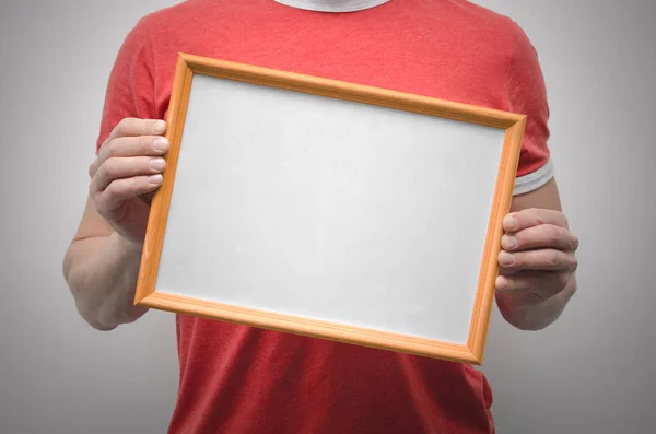 Man is holding a blank diploma or certificate frame border with copy space isolated on gray background.