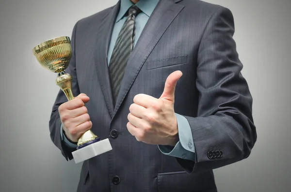 Biznesmen Rękach Trzyma Trofeum Nagrodę Złotego Pokazuje Kciuki Góry Białym — Zdjęcie stockowe
