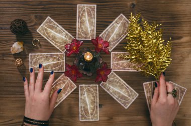 Tarot kartları ve falcı ahşap masa arka plan üzerinde eller.
