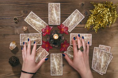 Tarot kartları ve falcı ahşap masa arka plan üzerinde eller.