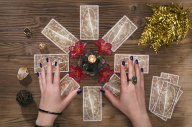 Tarot kartları ve falcı ahşap masa arka plan üzerinde eller.