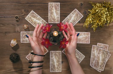 Tarot kartları ve falcı ahşap masa arka plan üzerinde eller.