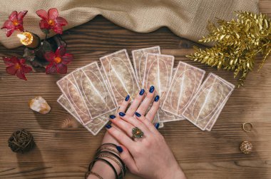 Tarot kartları ve falcı ahşap masa arka plan üzerinde eller.