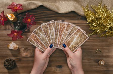 Tarot kartları ve falcı ahşap masa arka plan üzerinde eller.