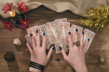 Tarot kartları ve falcı ahşap masa arka plan üzerinde eller.