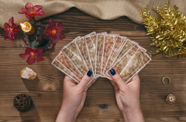 Tarot kartları ve falcı ahşap masa arka plan üzerinde eller.