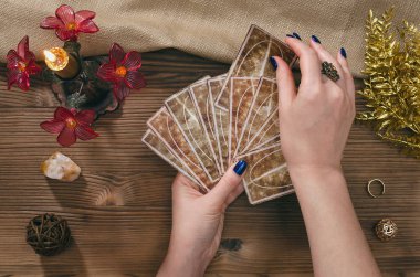 Tarot kartları ve falcı ahşap masa arka plan üzerinde eller.
