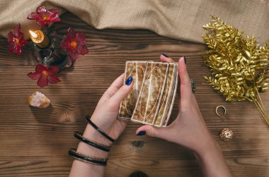 Tarot kartları ve falcı ahşap masa arka plan üzerinde eller.