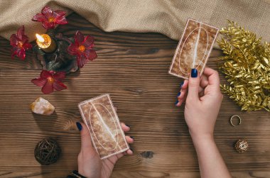 Tarot kartları ve falcı ahşap masa arka plan üzerinde eller.