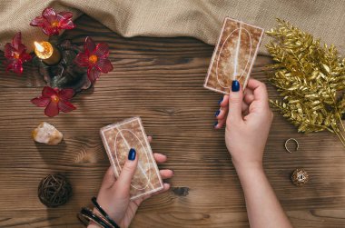 Tarot kartları ve falcı ahşap masa arka plan üzerinde eller.