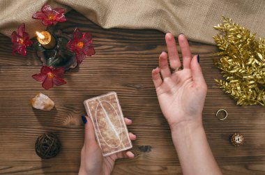 Tarot kartları ve falcı ahşap masa arka plan üzerinde eller.