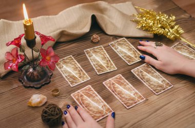 Tarot kartları ve falcı ahşap masa arka plan üzerinde eller.