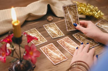 Tarot kartları ve falcı ahşap masa arka plan üzerinde eller.