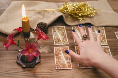 Tarot kartları ve falcı ahşap masa arka plan üzerinde eller.