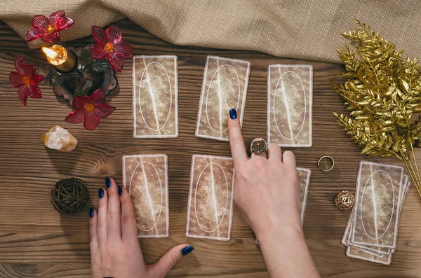 Tarot kartları ve falcı ahşap masa arka plan üzerinde eller.