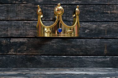 Altın Kral taç kopya alanı için benzersiz nesne altındaki ahşap duvar zemin üzerine. Sigorta primi ürün tanıtımı kavramı.