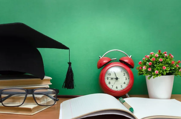 Stapel Bücher Leeres Notizbuch Abschlussmütze Und Roter Wecker Auf Dem — Stockfoto