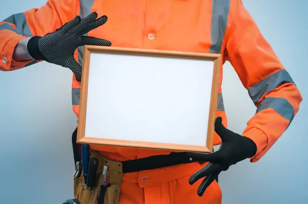 Blank builder certificate. Construction diploma. Contractor is showing a blank photo frame border in his hands. Housing project presentation.