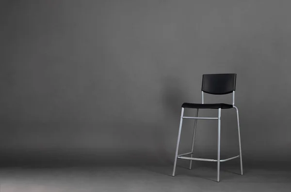 Black metal chair isolated on gray background with copy space in the studio.
