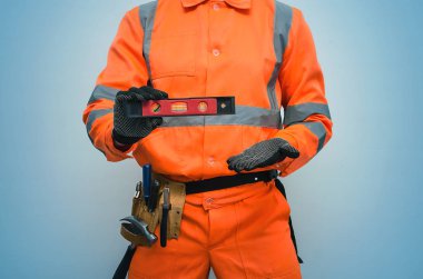 Elinde bir inşaat su seviyesi kapatmak Tarih izole mavi arka plan Oluşturucu tutar. 