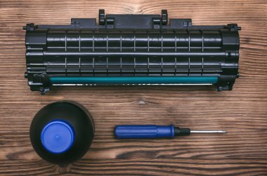 Lazer Yazıcı Kartuşu, tornavida ve şişe masanın üzerinde Toner. Ofis donanımları bakım kavramı.