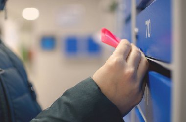 Kadın evde onun posta kutusundan bir reklam broşür tutuyor.