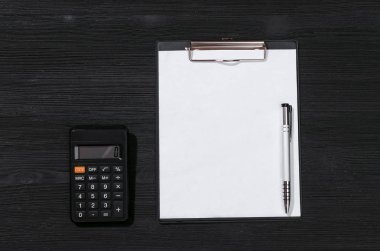 Vergi hesaplama kadar sahte. Ödeme hesabı. Boş belge sayfasına ve hesap makinesi siyah tablo arka planı.