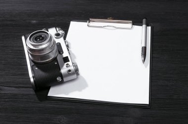 Liste mockup vurdu. Fotoğraf oturumu sözleşme şablonu. Vintage film fotoğraf makinesi ve siyah ahşap masa arka plan boş kağıt sayfası. Üstten görünüm fotoğraf.