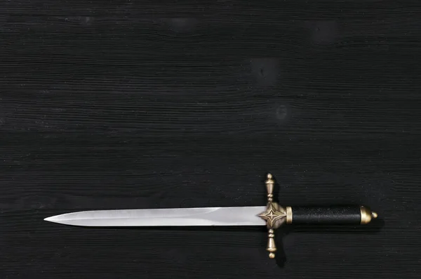 Siyah ahşap arka plan kopya alanı ile izole hançer bıçak.